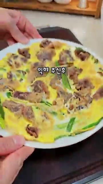 접시를 이용해 육전을 뒤집어 앞뒤로 노릇하게 익혀 완성한다. — 한판 육전: 차돌박이와 계란으로 만드는 초간단 명절 전 레시피