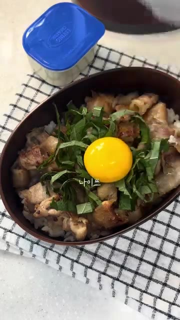 다진 깻잎을 올리고 계란 노른자를 가운데 올린 후 깨소금을 뿌린다. — 대패삼겹살 도시락 만들기