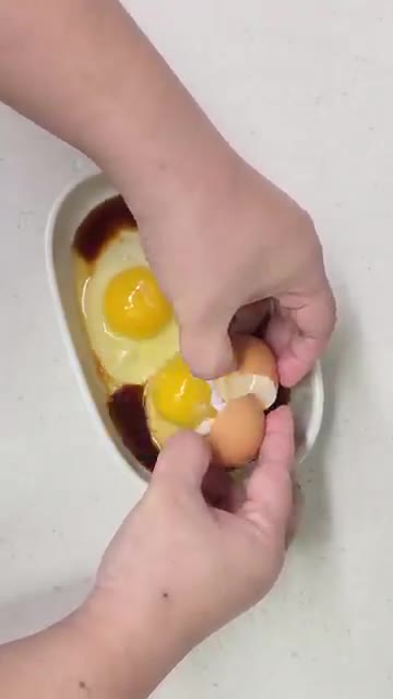계란 2개를 깨뜨려 넣고, 노른자를 포크로 찔러 터뜨려줍니다. — 전자레인지 5분 컷 간장계란밥