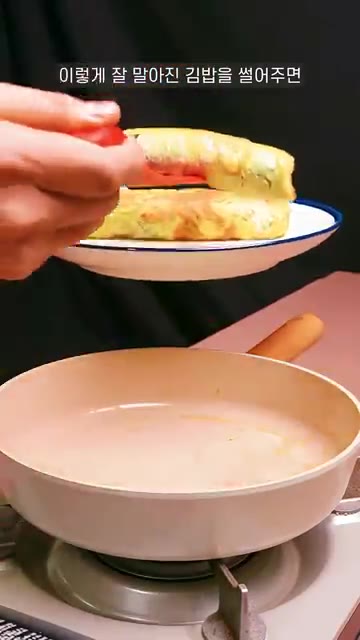 계란으로 잘 감싼 김밥을 팬에서 꺼내 먹기 좋게 썰어준다. — 납작 계란말이 김밥