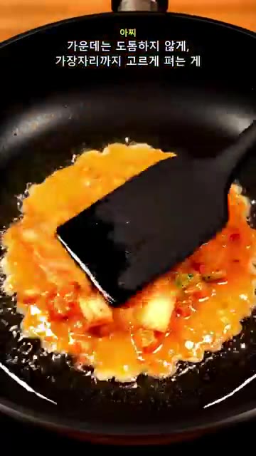 예열된 팬에 반죽을 얇고 넓게 펼쳐 올린다. — 김치전이 자꾸 눅눅하다면? 감자전분 반 컵 바삭한 비법