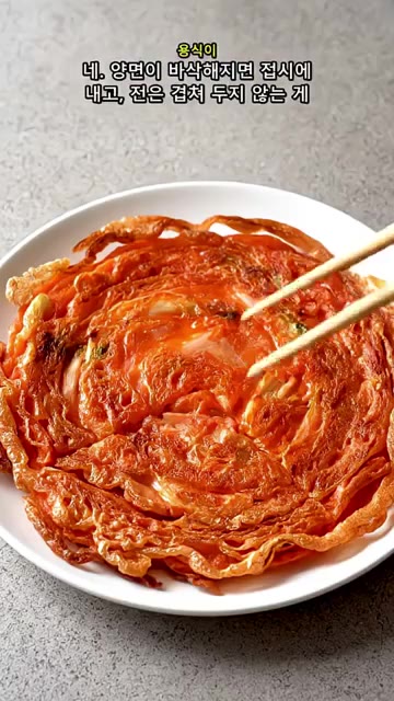 양면과 가장자리가 노릇하고 바삭하게 익으면 접시에 담아낸다. — 김치전이 자꾸 눅눅하다면? 감자전분 반 컵 바삭한 비법