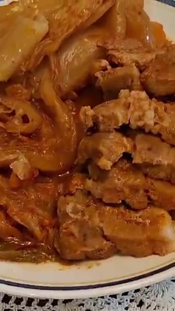 잘 익은 돼지고기 묵은지찜을 접시에 담아낸다. — 돼지고기 묵은지찜 레시피