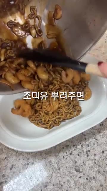 그릇에 담고 조미유를 살짝 뿌려 완성한다. — 감바스 짜파게티