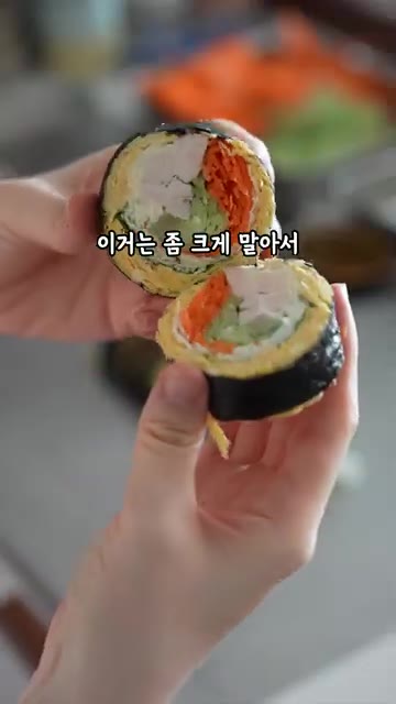 김밥을 먹기 좋은 크기로 썰어 참기름과 통깨를 뿌려 마무리한다. — 밥 빼야 더 맛있는 김밥