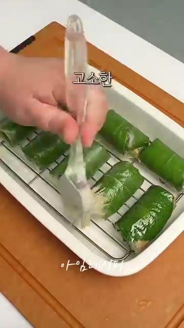 말아둔 묵은지 두부 깻잎말이 표면에 참기름을 살짝 발라줍니다. — 묵은지 두부 깻잎말이 레시피