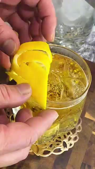 얼음이 담긴 잔에 술을 따르고 레몬 껍질 가니쉬를 꽂아 완성한다. — Don't throw away lemon peels...