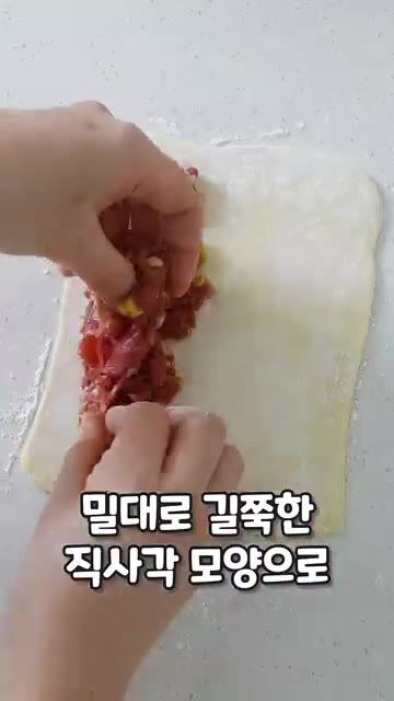 덧밀가루를 뿌린 패스츄리 생지를 길쭉한 직사각형 모양으로 밀어줍니다. — 불고기 롱파이 레시피