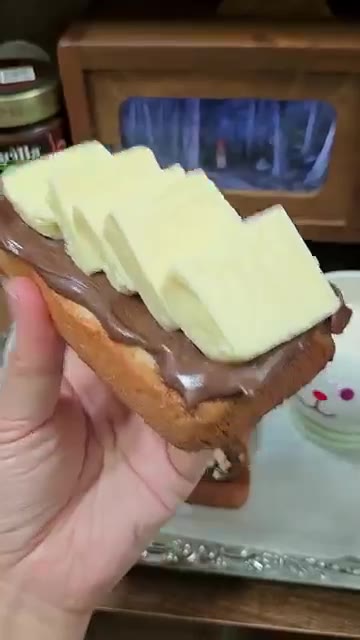 견과류를 뿌린 식빵 위에 버터를 올린다. — 초코버터토스트 헤이즐넛코코아 스프레드