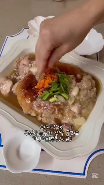 누룽지백숙을 그릇에 담고, 고명으로 부추와 당근을 올립니다. — 집에서 즐기는 여름철 보양식 누룽지백숙