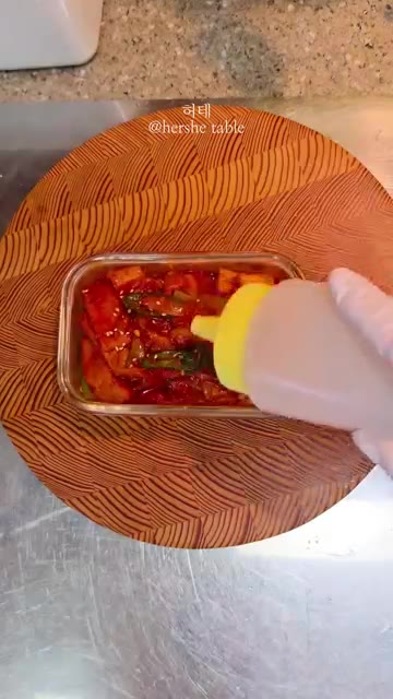 완성된 어묵 조림을 반찬통에 담고 참기름을 뿌린다. — 일주일 반찬 5가지 레시피