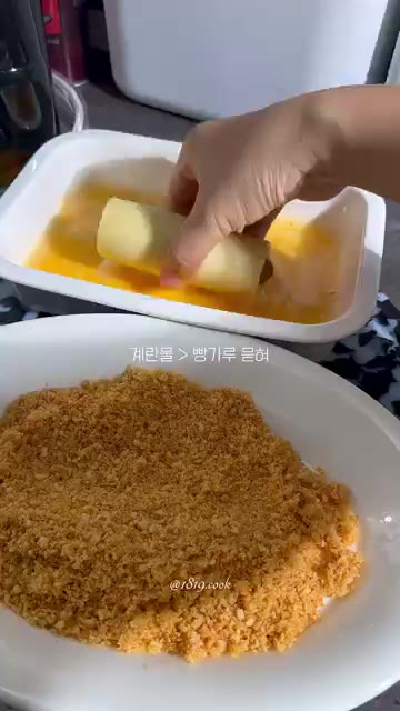 말아 놓은 소세지롤을 계란물에 담갔다가 빵가루를 골고루 묻혀줍니다. — 식빵 소세지 치즈롤 만들기