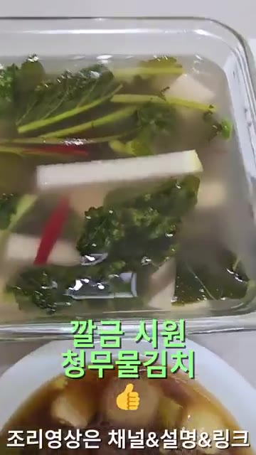 여수 갓김치를 집게로 들어 보여준다. — 26년 가을 집밥일기: 청양 데리야끼 닭다리살과 다양한 김치, 장조림 등