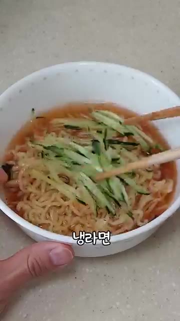 라면을 찬물에 헹궈 전분기를 뺀다. 오이를 채 썬다. — 초간단 냉라면 만들기