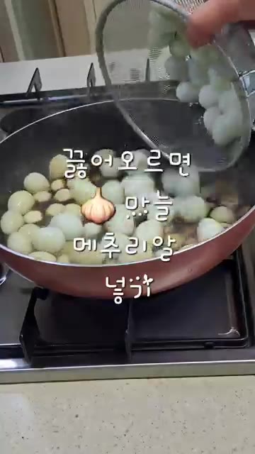 끓는 양념장에 마늘과 삶은 메추리알을 넣는다. — 급식대가 비법 메추리알 장조림