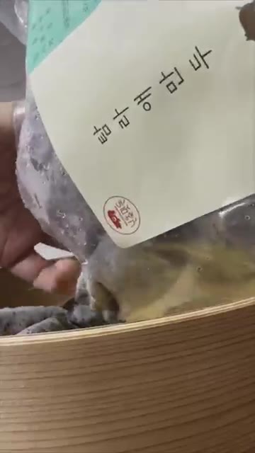 찜기 위에 노란 김발을 깔고 만두를 올린다. — 제주도 흑돼지 만두, 어떤 맛일까?