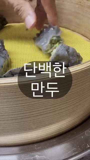 만두를 찜기에 넣고 찐다. 완성된 만두를 집어 단면을 보여준다. — 제주도 흑돼지 만두, 어떤 맛일까?