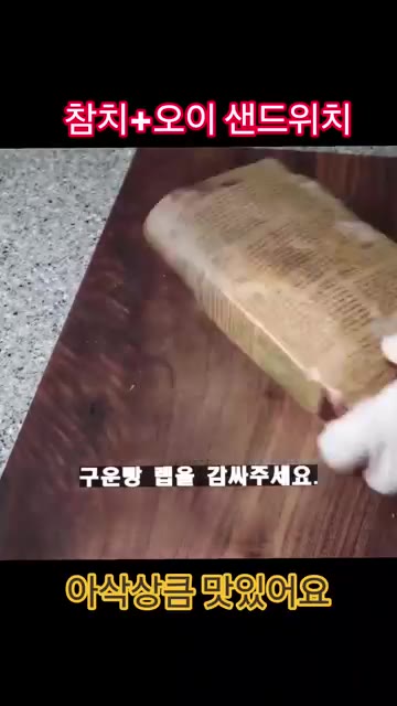 랩으로 빵을 감싸 반으로 잘라 포장지로 감싸 고정하면 완성입니다. — 참치 오이는 이렇게 드세요!