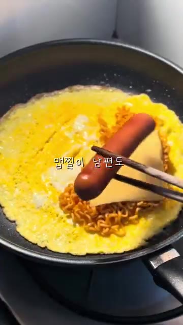 익힌 불닭볶음면, 체다치즈, 소시지를 계란 위에 올립니다. — 불닭 오믈렛 레시피