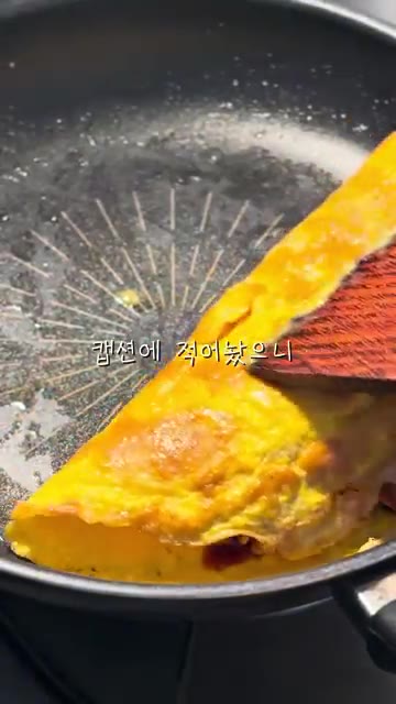 계란을 반으로 접고, 김가루와 깨를 뿌려 마무리합니다. — 불닭 오믈렛 레시피
