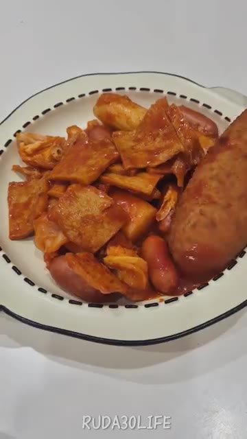 핫도그 안의 치즈가 늘어나는 모습을 보여준다. — 떡볶이에 핫도그