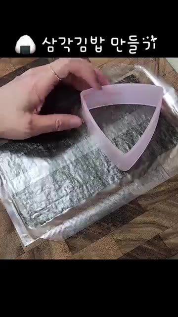 삼각김밥 틀에 김을 깔고 밥을 꾹꾹 눌러 삼각김밥 모양으로 만든다. — 명란마요에 청양고추 넣었더니… 삼각김밥이 미쳤어요