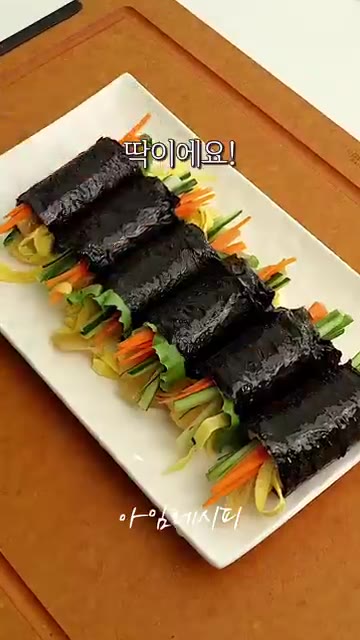 김 끝부분에 물을 살짝 발라 고정시킨 후, 먹기 좋게 잘라 완성합니다. — 두부 야채 김밥 만들기 (밥 없이)