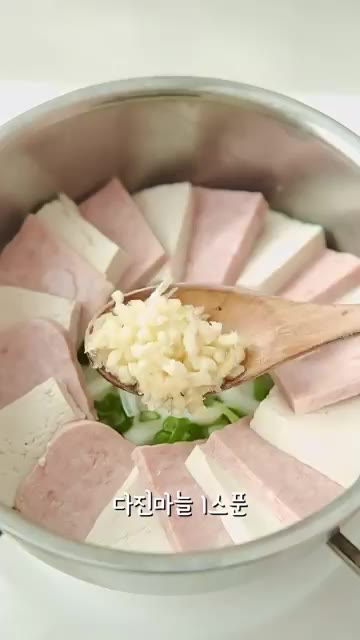 냄비에 썰어둔 양파와 대파를 깔고 스팸과 두부를 보기 좋게 올린다. — 찬바람 불 때 뜨끈한 스팸두부짜글이