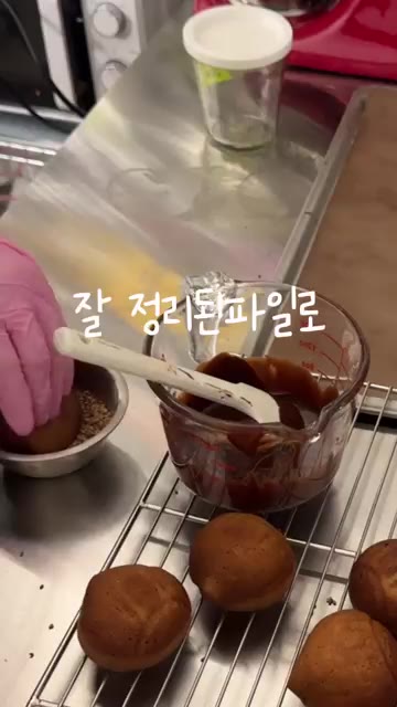 완성된 떡의 아랫부분을 초콜릿에 찍고 깨를 묻힌다. — 버터떡보다 맛있는 마롱찰떡 레시피 공개