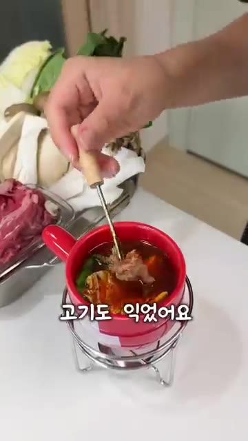 작은 냄비에 육수를 붓고 양초에 불을 붙여 데운다. — 양초 하나로 훠궈 만들어 먹기?!