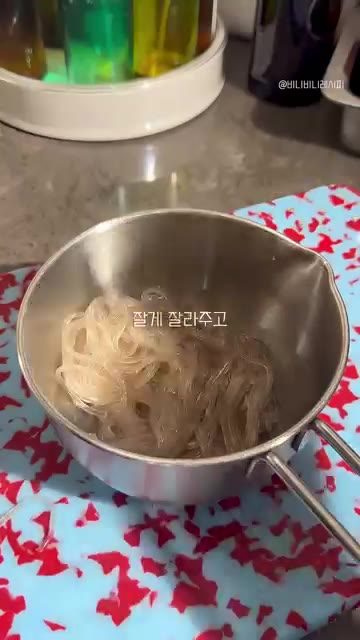 삶은 당면을 냄비에 옮겨 담는다. — 당면 계란만두 만들기