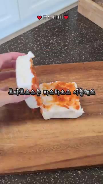떡을 반으로 갈라 파스타 소스를 바른다. 옥수수를 올린다. — 피자설기 만들기