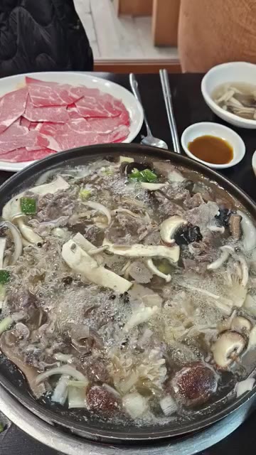 육수가 끓으면 얇게 썬 소고기를 넣고 익힌다. — 맛있는 버섯 전골