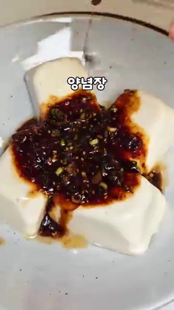 연두부 위에 양념장을 붓고 쪽파와 통깨를 뿌려 완성한다. — 성시경 살 뺄 때 먹는 연두부