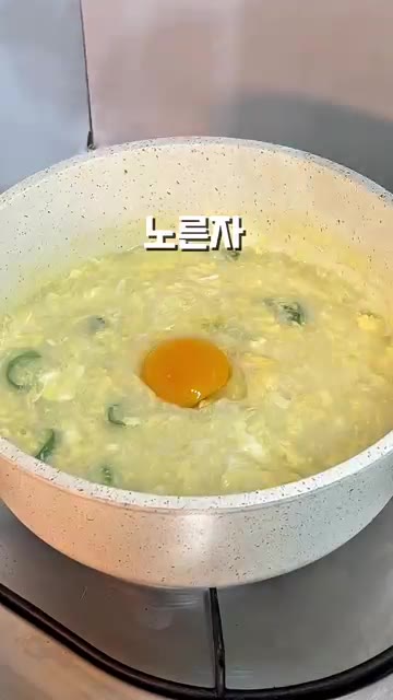 가운데에 노른자를 올리고 참깨를 뿌린다. — 뜨끈한 계란죽