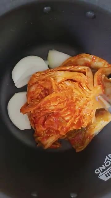 돼지고기 위에 김치 양념을 올린다. — 밥솥 버튼 하나로 끝! 묵은지 김치찜