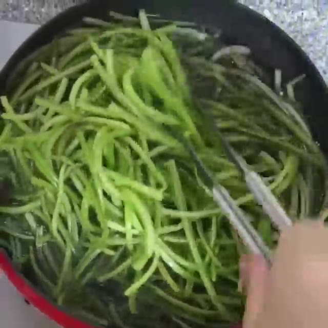 삶아진 고구마줄기를 집게로 건져내어 골고루 삶아지도록 한번씩 뒤적여… — 제철채소 고구마줄기 볶음