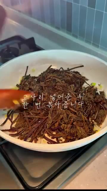 고사리를 넣고 한 번 볶아줍니다. 국간장 1큰술을 넣어줍니다. — 삶은 고사리 볶음