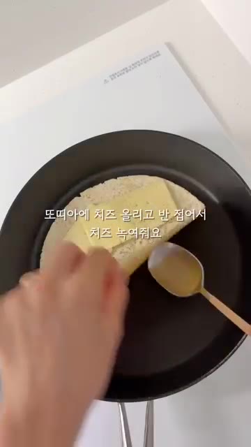 또띠아 위에 치즈를 올리고 반으로 접어 팬에 올린다. — 120cm 21.6kg 초딩 간식 일기: 또띠아 닭가슴살 콘치즈