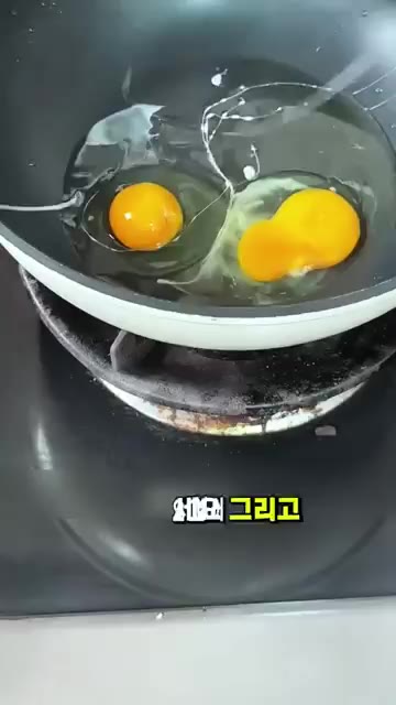 팬에 기름을 두르고 달걀 4개를 깨뜨려 넣는다. 마늘도 함께 넣는다. — 밥 한 공기 뚝딱 비우는 단짠단짠 달걀 요리 꿀팁✨