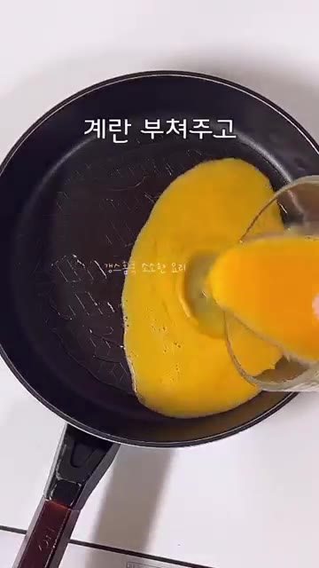 달걀에 소금을 넣고 풀어 계란말이를 만들어 반으로 자른다. — 개운 깔끔 묵은지 참치김밥 레시피