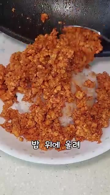 밥 위에 볶은 두부를 올리고 썬 대파를 고명으로 올린다. — 두부덮밥