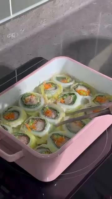 완성된 알배추 고기말이 전골을 건져 소스와 함께 즐깁니다. — 알배추 고기말이 전골
