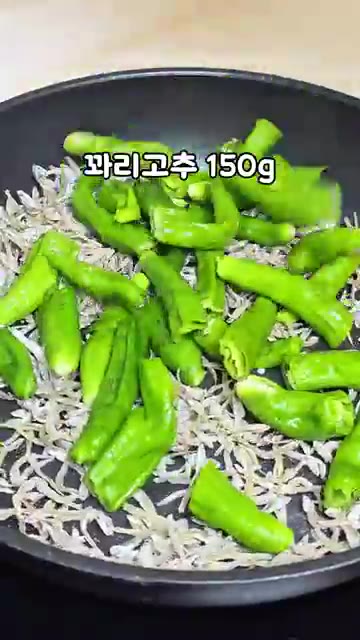 꽈리고추 150g을 반으로 잘라 넣고 1분 정도 볶아주세요. — 정호영 셰프의 꽈리고추 멸치볶음