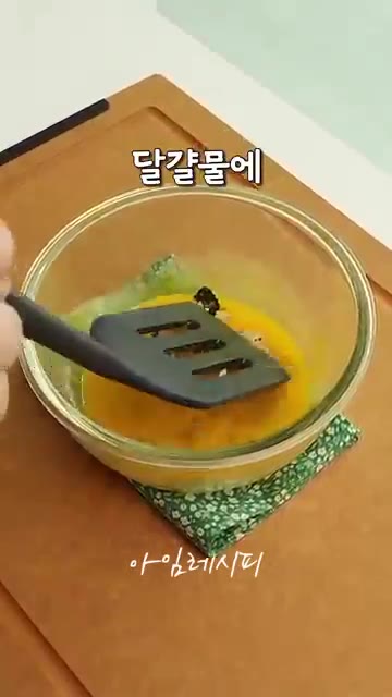 밥을 올린 조미김을 뒤집개로 떠서 달걀물에 담갔다가 건진다. — 국도 반찬도 필요없는 방학한끼! 달걀햄밥전