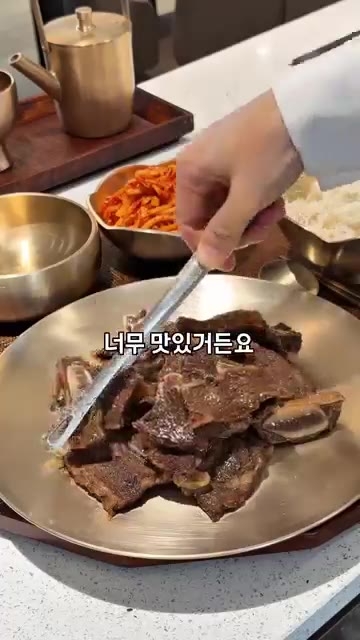 구워진 LA갈비를 접시에 담는다. 밥과 김치, 조개탕을 곁들인다. — LA갈비와 매운 갈비찜 레시피