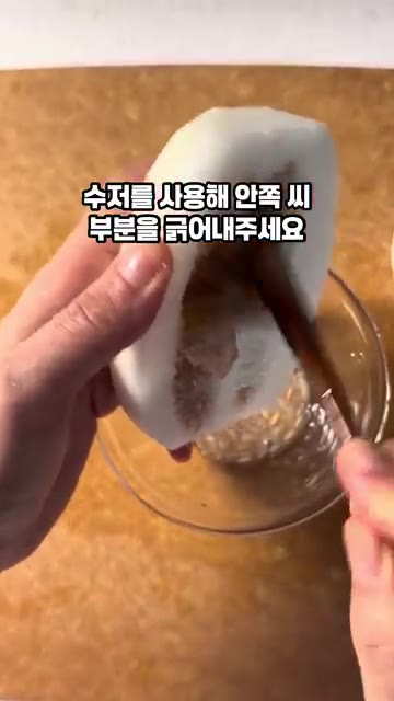 참외를 반으로 자르고 수저를 사용해 안쪽 씨 부분을 긁어냅니다. — 참외 샐러드 드레싱 소스 만들기