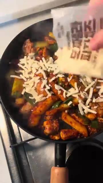 모짜렐라 치즈를 듬뿍 뿌려 녹인다. — 매콤 닭구이 치즈 볶음