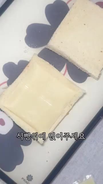 납작하게 민 식빵 위에 모짜렐라 치즈를 올리고 데친 소세지를 올려… — 출근길 5분컷 소세지빵
