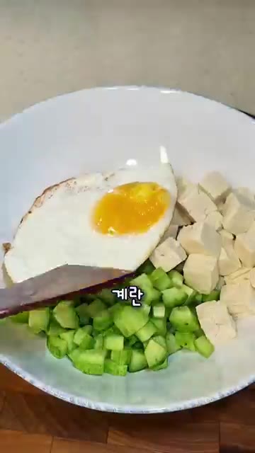 계란 프라이와 익힌 명란을 올립니다. 김가루와 통깨를 뿌립니다. — 오이 두부 명란 계란 비빔밥